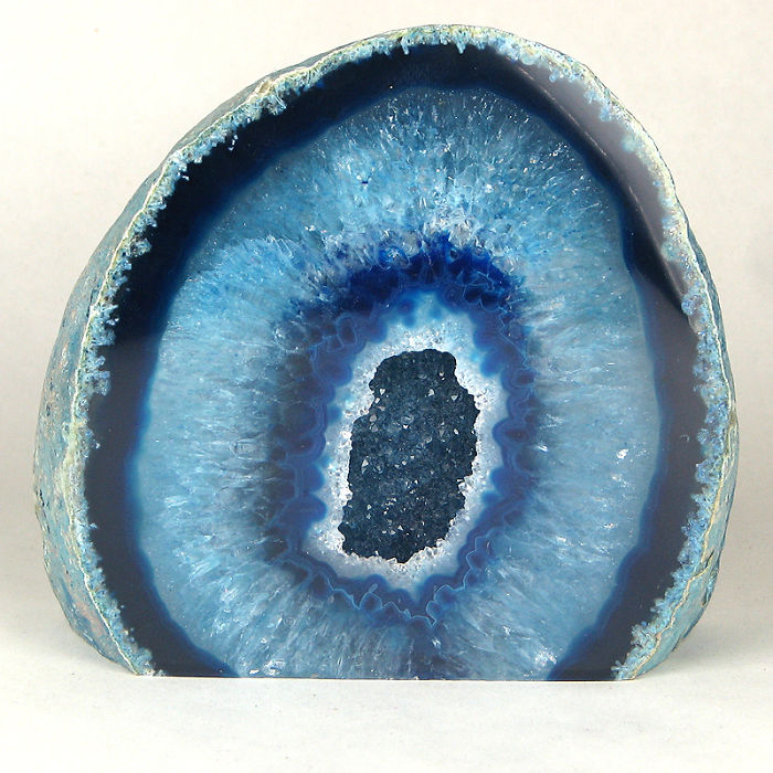 A beautiful blue mineral geode with crystal formations displayed in cross-section.