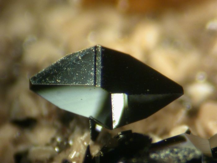 Close-up of a black, glossy mineral, capturing its sharp edges and reflective surface.