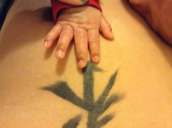 Baby hand resting on tattooed skin, showcasing the bond between tattooed parents and babies.