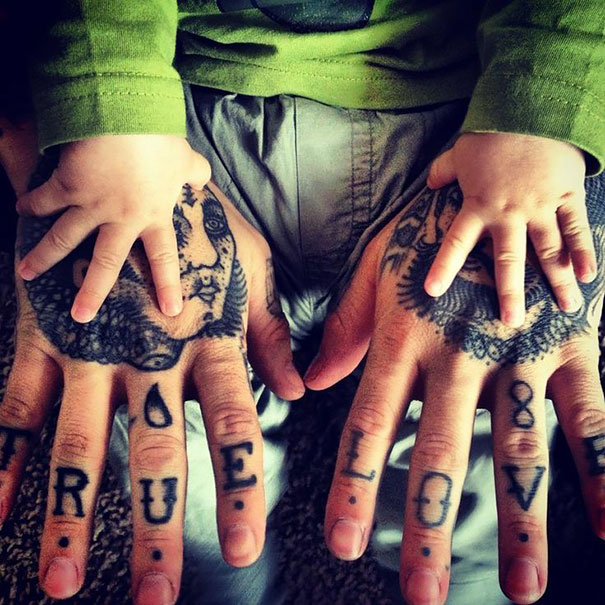 Tattooed parent's hands with a baby, emphasizing “true love” theme through matching tattoos.