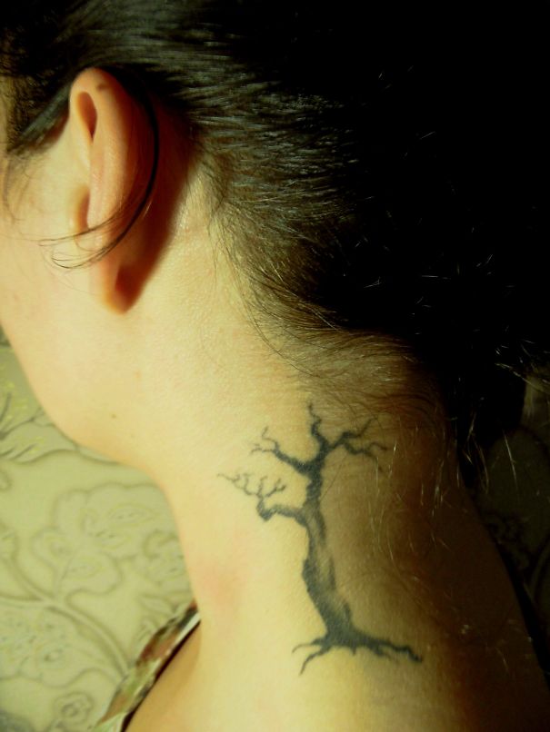 Tree tattoo behind the ear, showcasing creative ear art.