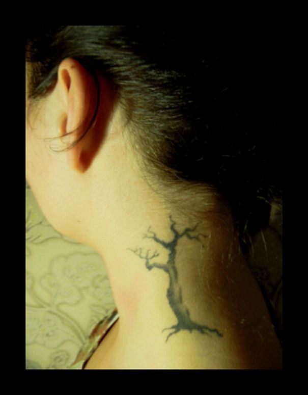 Creative ear tattoo with a tree design behind the ear.