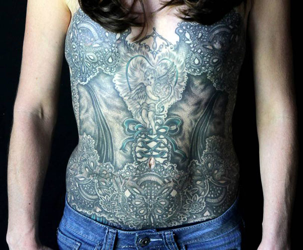 Breast cancer survivor with a detailed tattoo art covering mastectomy scars.