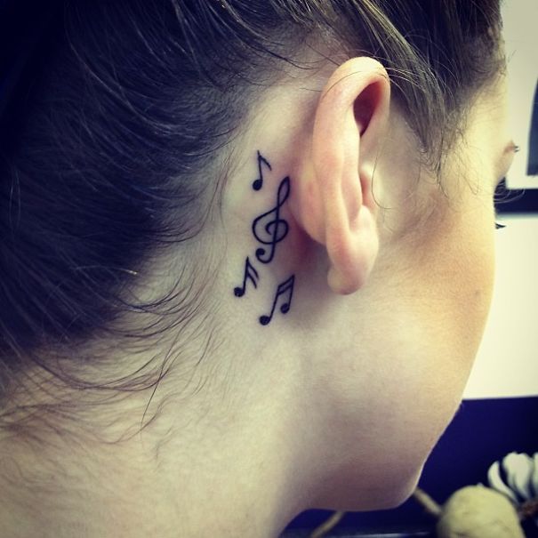 Creative ear tattoo with musical notes behind the ear.