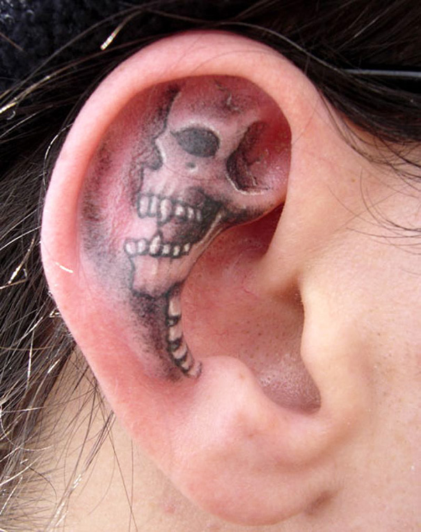 Skull ear tattoo, showcasing creative ear tattoo design against the ear's natural curves.