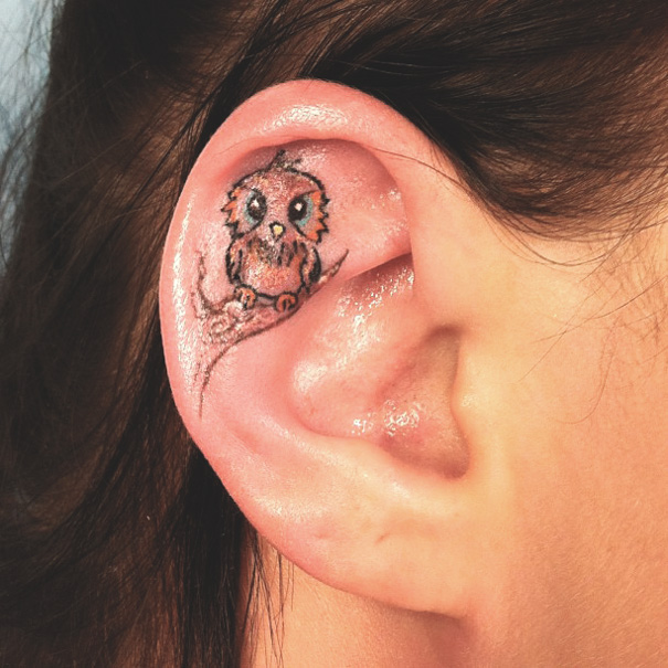 Cute owl tattoo on ear, showcasing creative ear tattoo design.