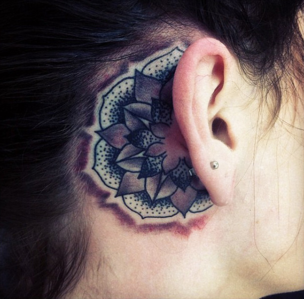 Creative ear tattoo featuring a mandala design behind the ear.