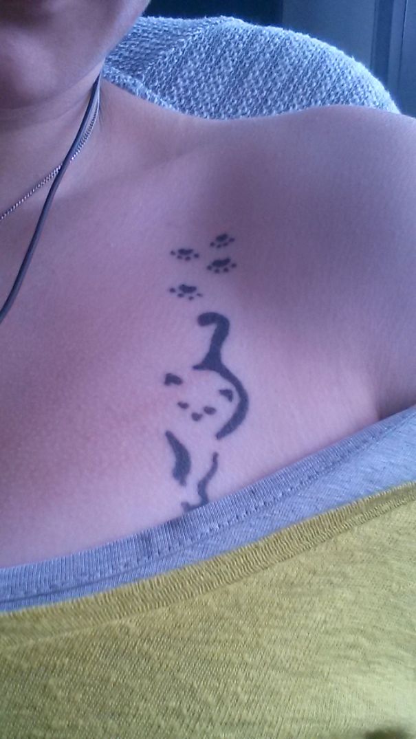 Simple cat tattoo design on shoulder with paw prints, featuring clean line art.