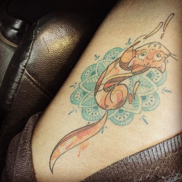 Line art cat tattoo design on a person's thigh, featuring playful colors and intricate patterns.