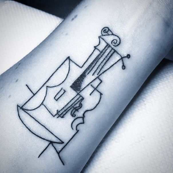 Picasso-inspired tattoo on forearm with abstract violin design, showcasing minimalist art.