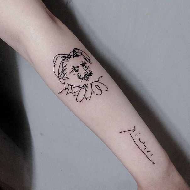 Picasso-inspired tattoo on a forearm featuring abstract lines and signature for art lovers.