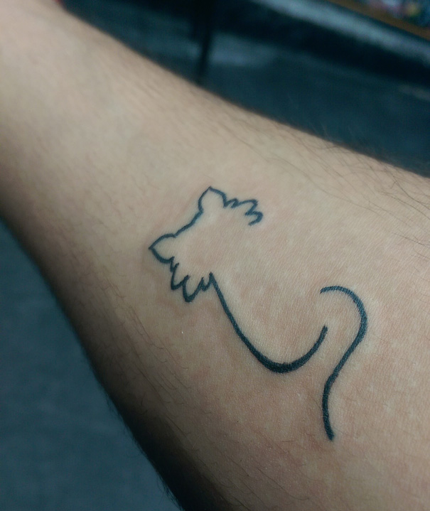 Line art tattoo of a cat silhouette on forearm for cat lovers.
