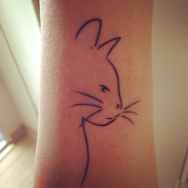 Simple cat tattoo design in line art style on arm, ideal for cat lovers.