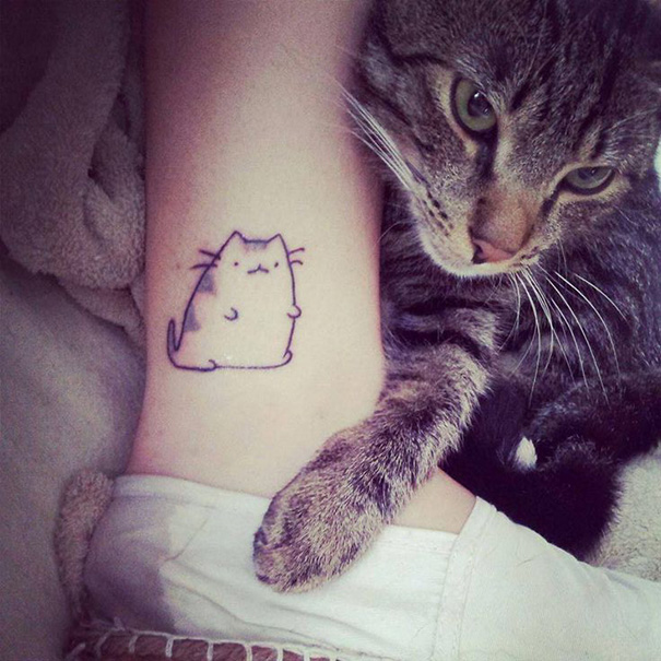 Line art cat tattoo on leg with real cat touching, showcasing simple tattoo design for cat lovers.