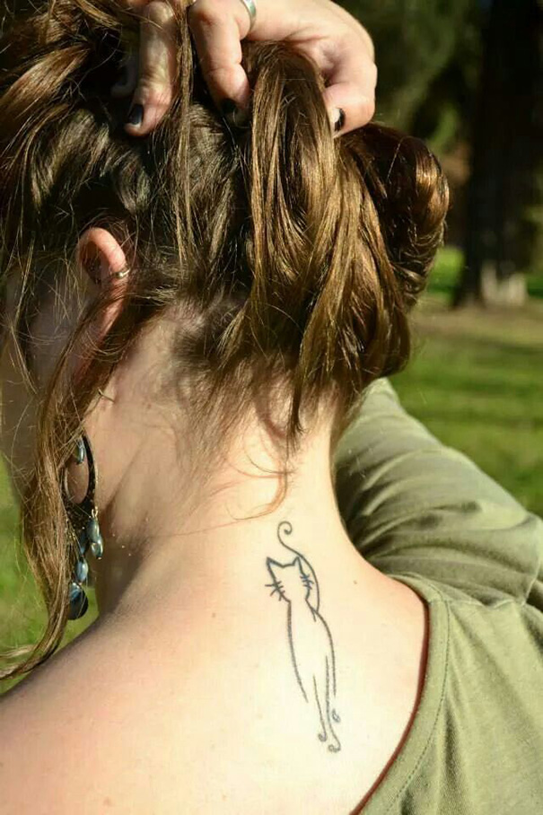 Line art cat tattoo on a person's neck, simple design for cat lovers.