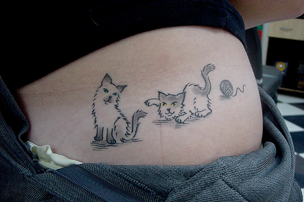 Simple cat tattoo design in line art on skin, featuring playful kittens and a yarn ball.