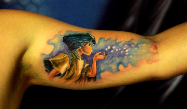 Studio Ghibli tattoo featuring a character blowing sparkles on an arm, inspired by Miyazaki films.