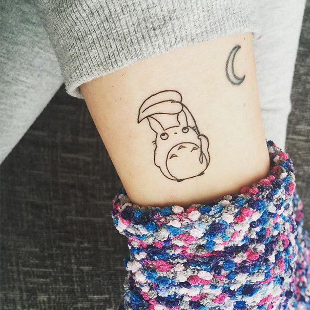 Studio Ghibli tattoo with Totoro design on an arm, inspired by Miyazaki films.