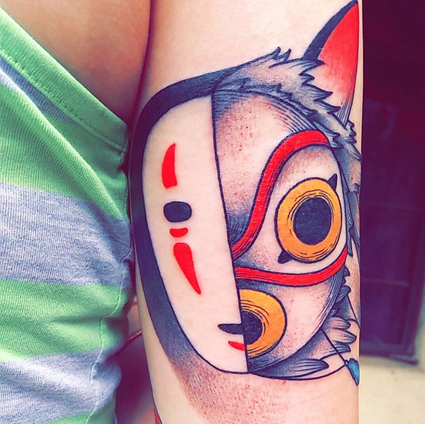 Studio Ghibli tattoo featuring a colorful Princess Mononoke mask on an arm.