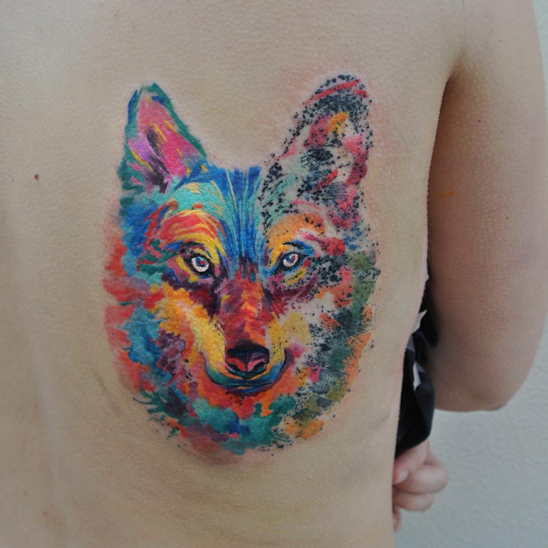 Colorful watercolor tattoo of a wolf by Czech artist, showcasing vibrant artistry. Colorful watercolor tattoo of a wolf by Czech artist, showcasing vibrant artistry.