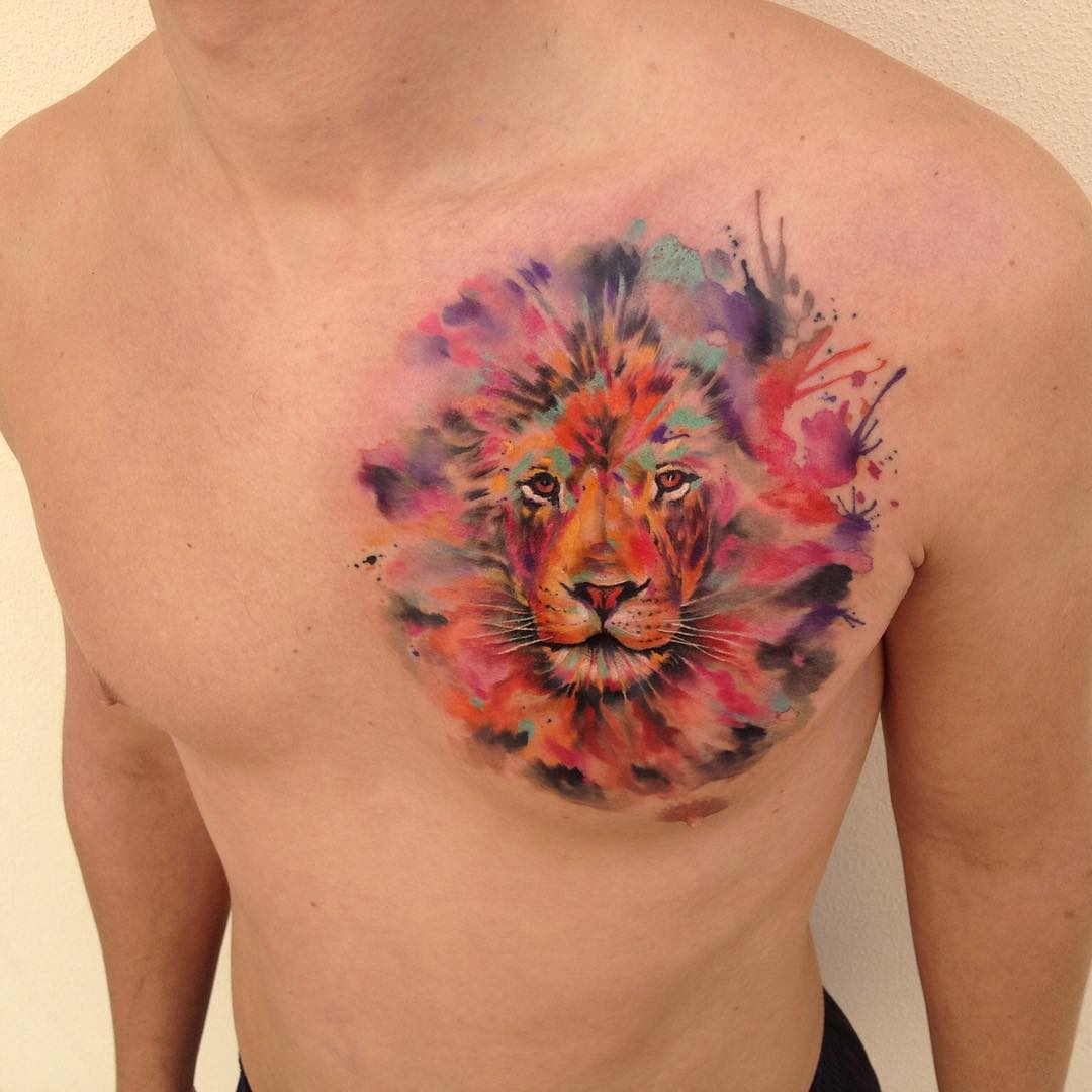 Colorful lion watercolor tattoo on chest, showcasing the artistry of Czech tattoo artist Ondrash Ondrej Konupcik.