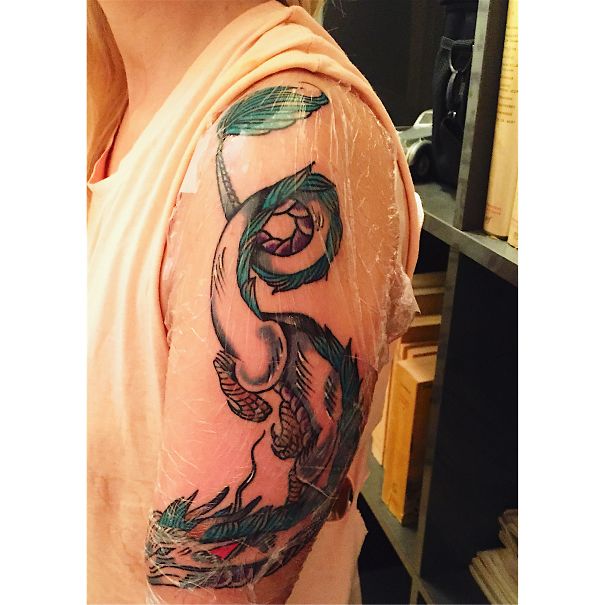 Miyazaki-inspired Studio Ghibli tattoo of a dragon on an upper arm, with bright colors and detailed design.
