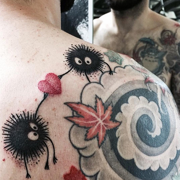 Studio Ghibli tattoo featuring soot sprites and heart on shoulder, inspired by Miyazaki films.