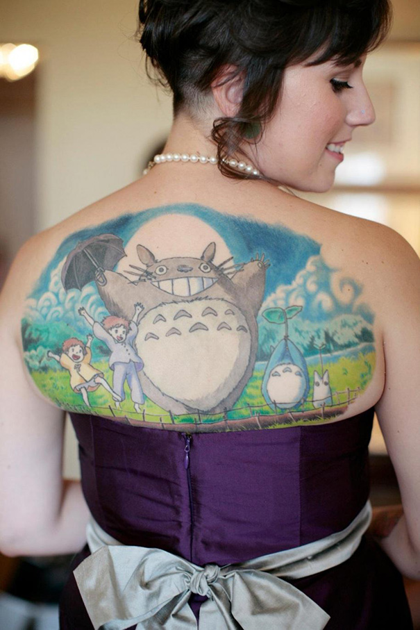 Studio Ghibli tattoo featuring Totoro and friends on woman's back, inspired by Miyazaki films.