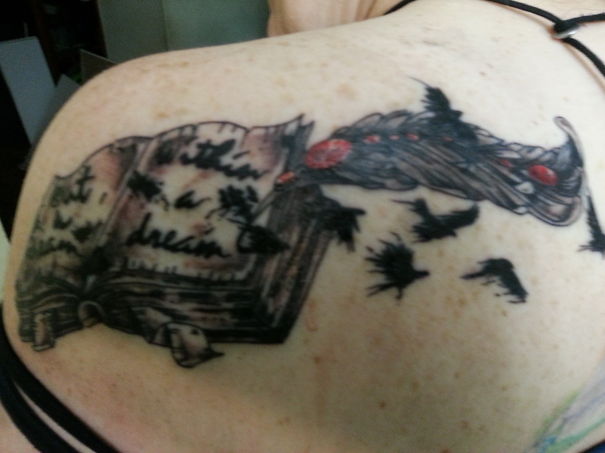Tattoo of an open book with birds flying, inspired by literature for bookworms.