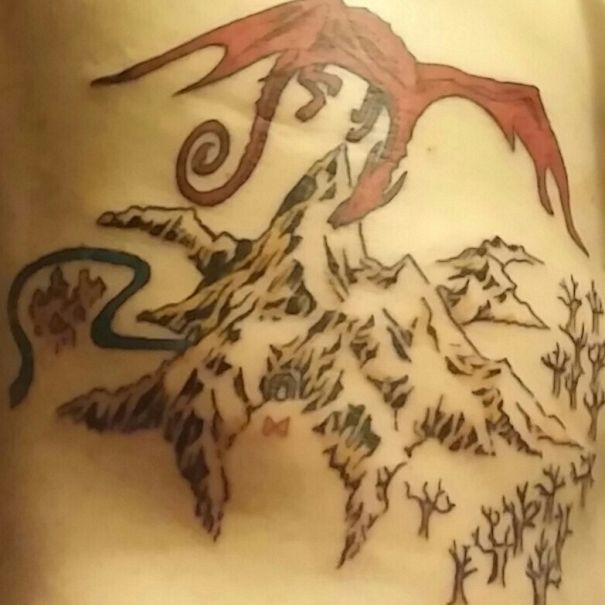 Dragon and mountain tattoo inspired by a book, featuring intricate designs and shading for bookworms.
