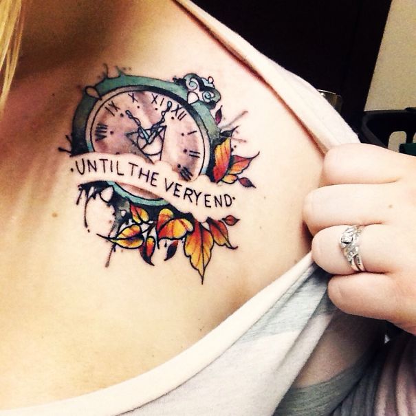 Tattoo of a clock with leaves and the phrase "Until the very end" on a bookworm's shoulder.