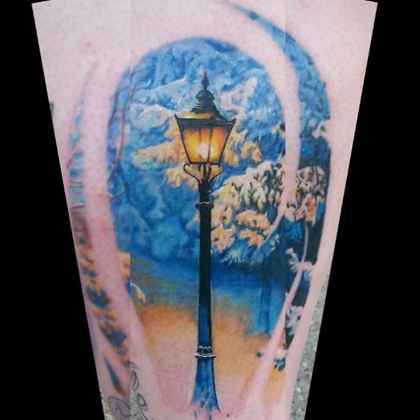 Book-inspired tattoo featuring a lamp post under a snowy sky, ideal for bookworms.