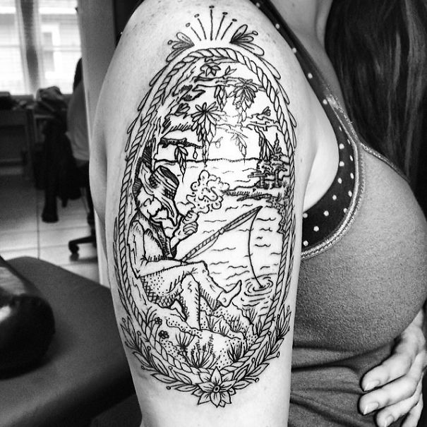 Book-inspired tattoo of a person fishing, framed by nature design, on an arm.