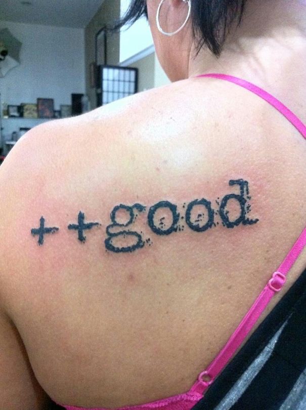 Tattoo of the word "good" with plus signs on shoulder, inspired by book elements.