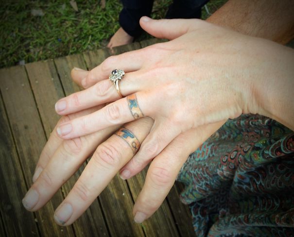 Matching wedding tattoos on couple's ring fingers instead of traditional rings, showcasing unique commitment.