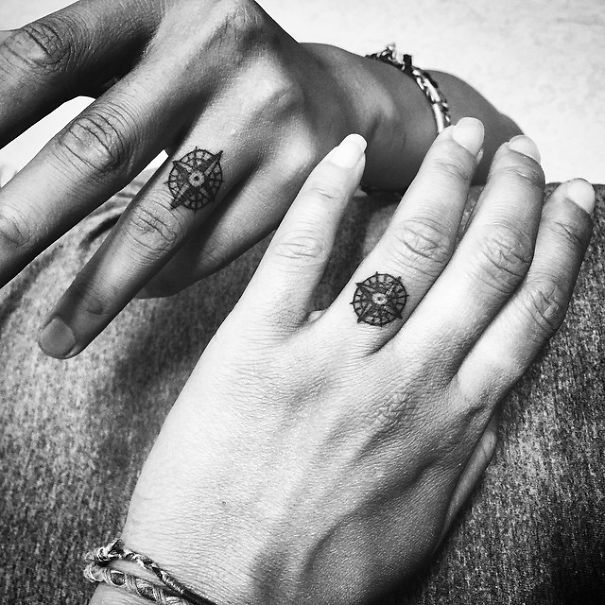 Matching wedding tattoos on a couple's fingers replacing traditional rings.