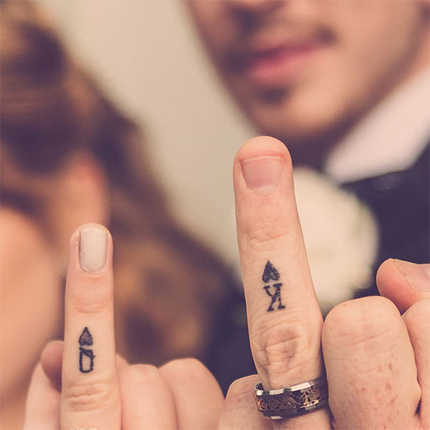 Couple's matching wedding tattoos on fingers, replacing traditional rings.