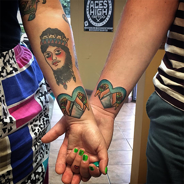 Matching wedding tattoos on a couple's arms, featuring colorful art and interlocking designs.