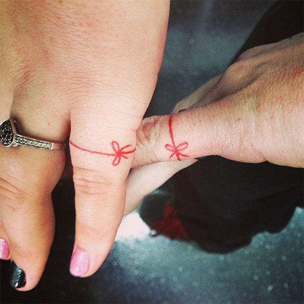 Couples with matching wedding tattoos as red string bows on their fingers.