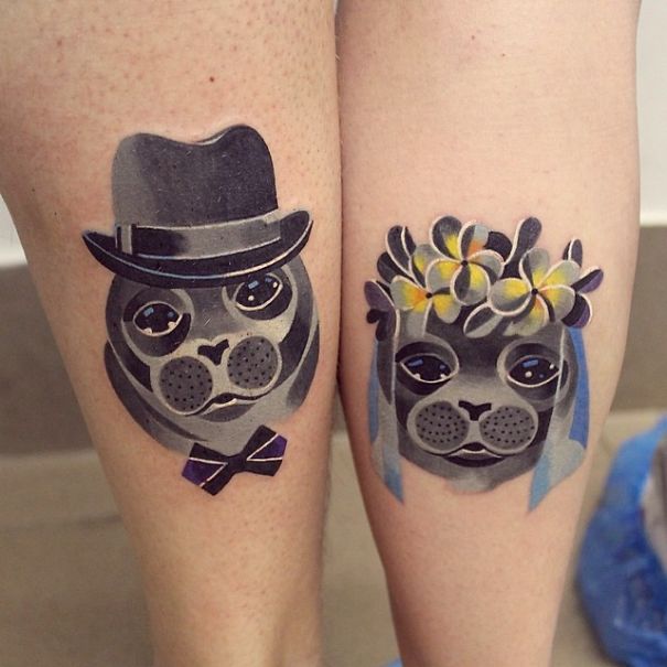 Matching wedding tattoos of a seal couple, one in a hat and bowtie, the other with flowers and a veil.
