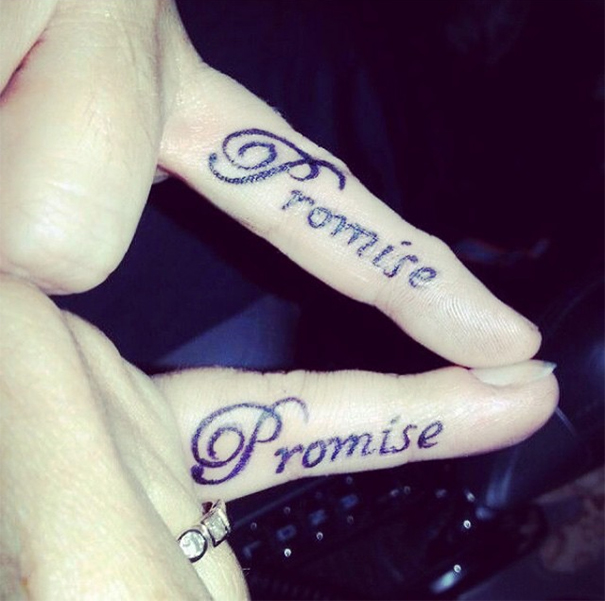 Matching wedding tattoos reading "Promise" on couple's fingers.