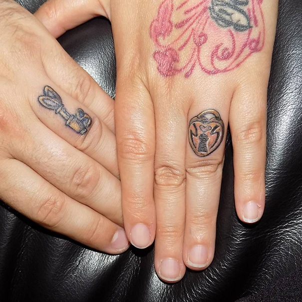 Matching wedding tattoos on fingers instead of rings, with a lock and key theme.