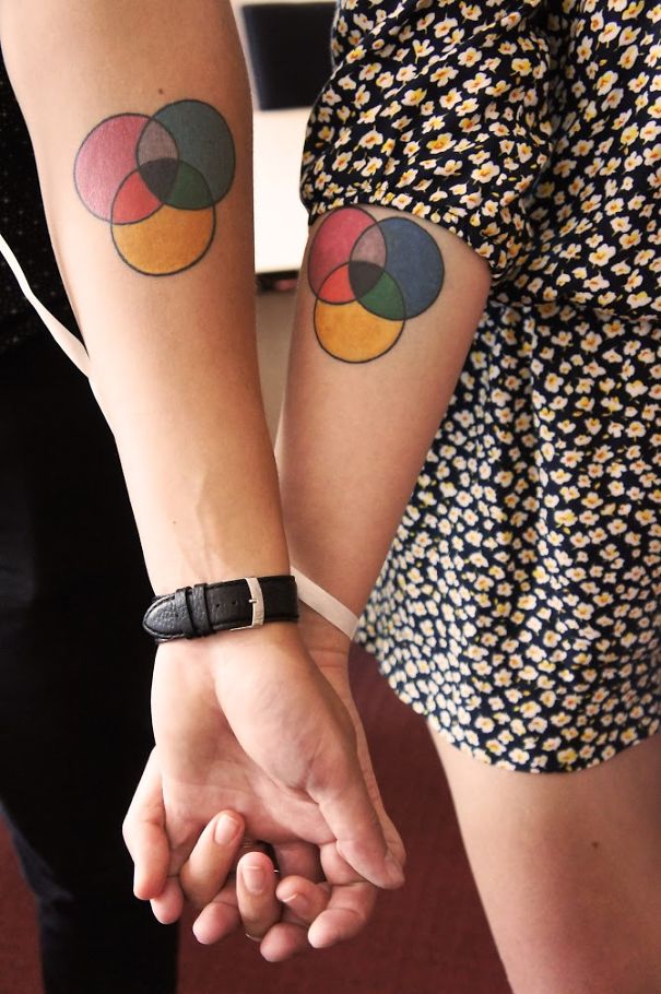 Matching wedding tattoos of colorful overlapping circles on a couple's arms.