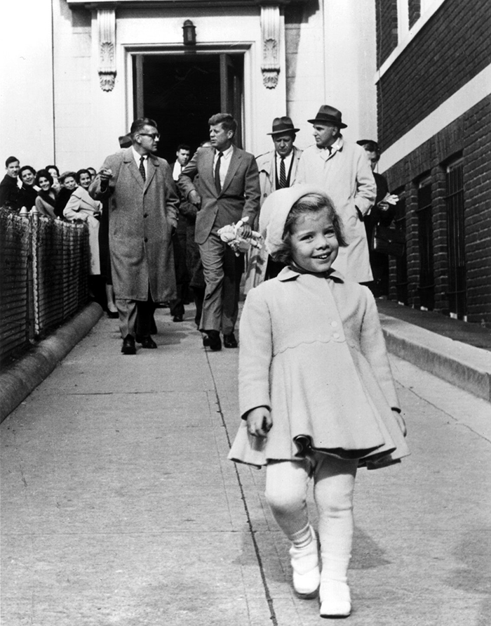 Caroline Kennedy Walks In Front Of Her Father, President Of United States, While He Carries Her Doll (1963)