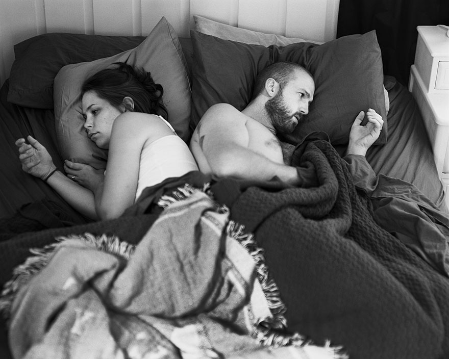 A black and white portrait of a couple in bed showing phone addiction removed from their hands by the photographer. A black and white portrait of a couple in bed showing phone addiction removed from their hands by the photographer.