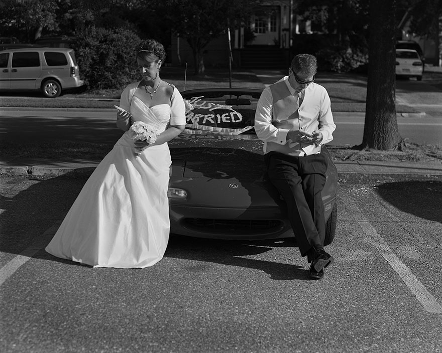 Bride and groom in wedding attire leaning on car, digitally edited to remove phones, illustrating phone addiction in portraits. Bride and groom in wedding attire leaning on car, digitally edited to remove phones, illustrating phone addiction in portraits.