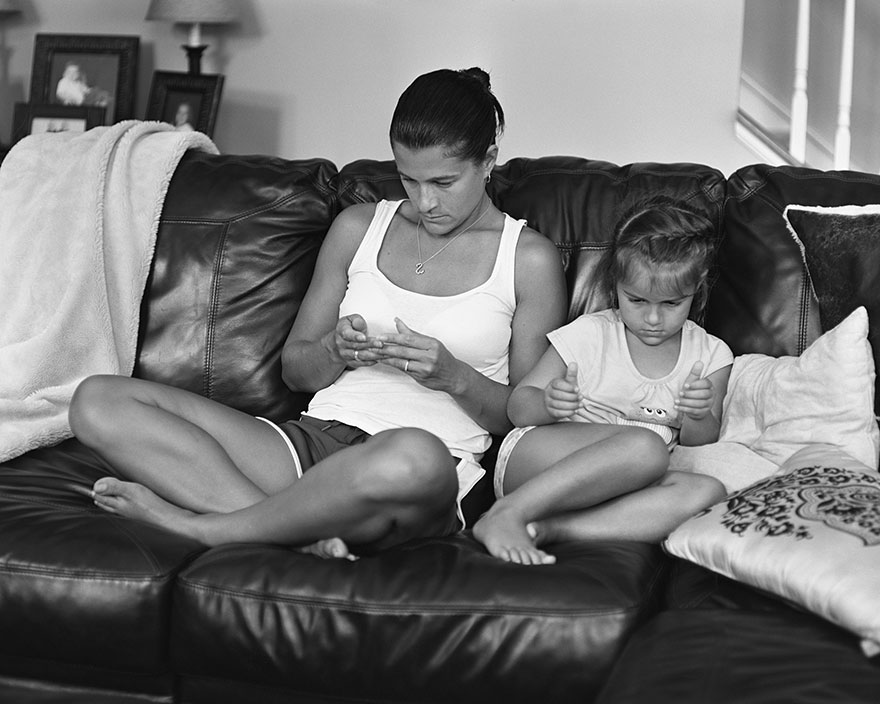 Woman and child sitting on a couch with devices removed from their hands, illustrating phone addiction by photographer Eric Pickersgill. Woman and child sitting on a couch with devices removed from their hands, illustrating phone addiction by photographer Eric Pickersgill.