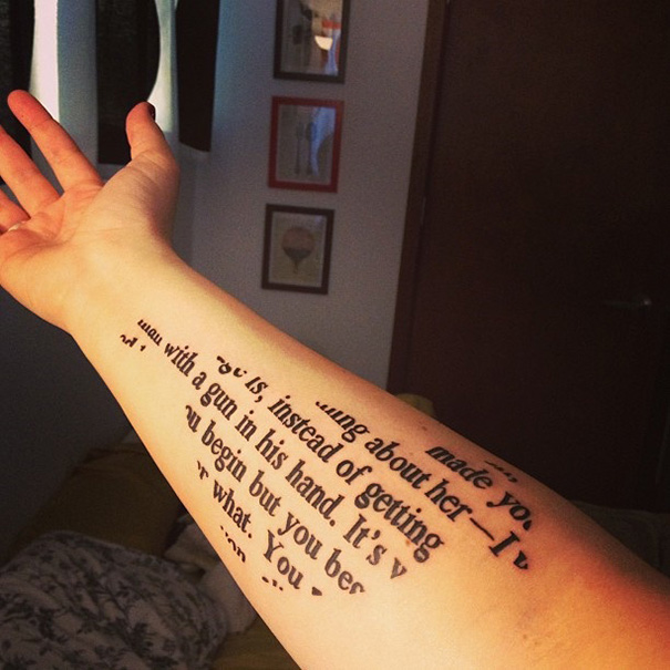 Forearm with a book-inspired tattoo, featuring italicized text on the skin, perfect for bookworms.