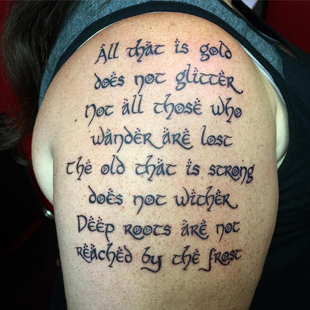 Tattoo of a famous book quote in elegant script on a person's upper arm.