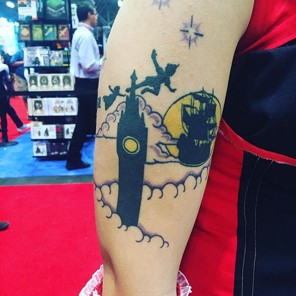 Tattoo of flying silhouettes over a clock tower, inspired by a classic book for bookworms.